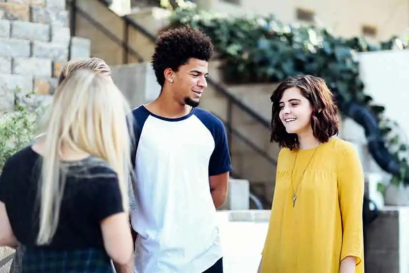 Group of teens in discussion in the outdoors. Medical marijuana education has helped protect teenagers from abusing the substance.