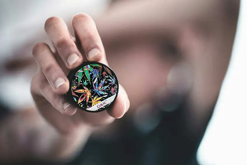 A hand holding up a medical marijuana product, with selective focus