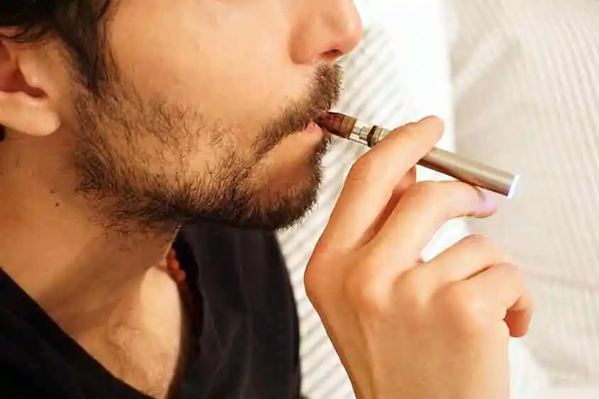 Closeup of man using a vape pen