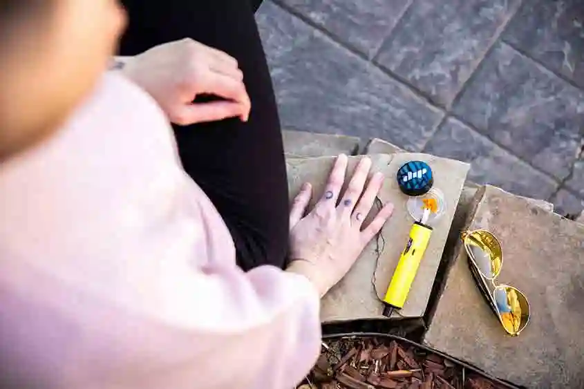 Person in the outdoors with a cannabis concentrate device