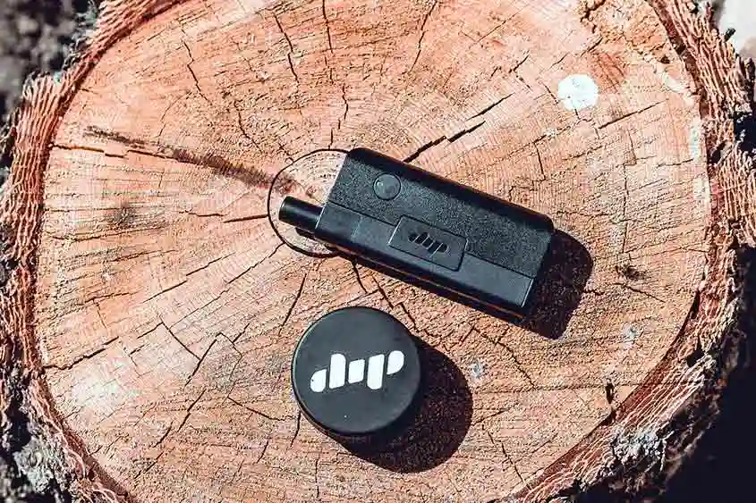 Cannabis vape device on a tree stump.