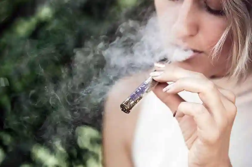 A woman using a vaporizer