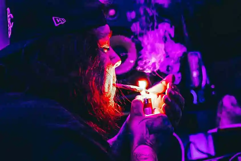 Colorful image of a man lighting a joint