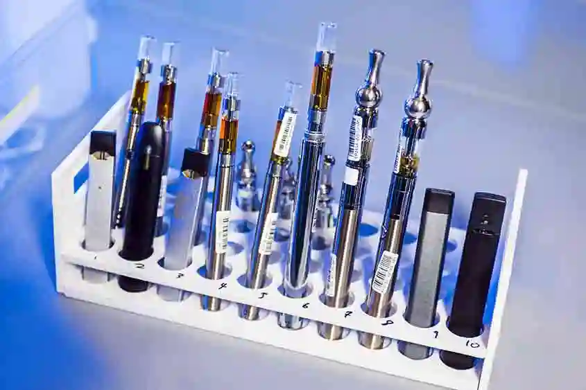 Different types of vapes and cartridges on display with bar code stickers.