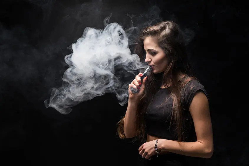 Young woman using a vaporizer